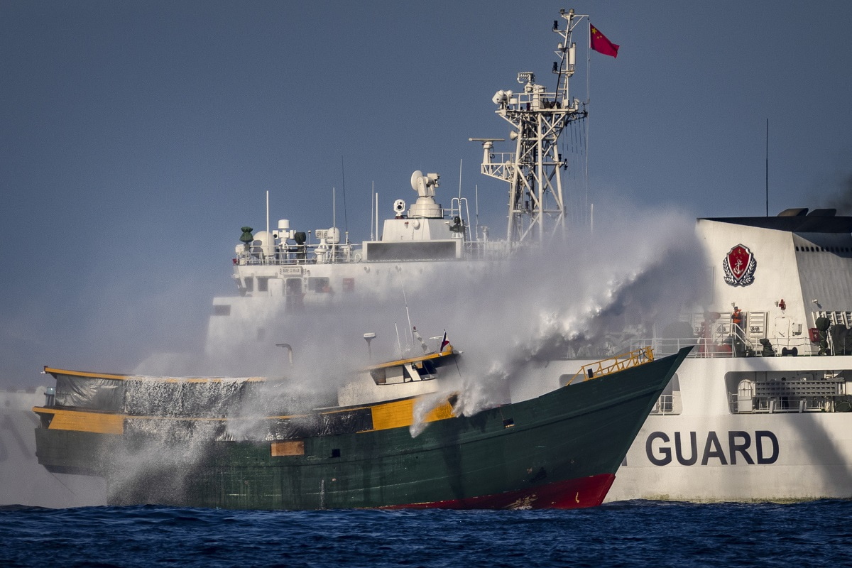 SOUTH CHINA SEA - MARCH 05: A Chinese Coast Guard ship fires a water cannon at Unaizah May 4, a Philippine Navy chartered vessel, conducting a routine resupply mission to troops stationed at Second Thomas Shoal, on March 05, 2024 in the South China Sea. Philippine and Chinese vessels collided in the high seas, leaving four Filipinos with minor injuries after a supply vessel's windshield was shattered by water cannons, the Philippines said. The incidents happened as the Philippines was conducting a routine resupply mission to troops stationed aboard BRP Sierra Madre, a grounded Navy ship that serves as the country's outpost in Second Thomas Shoal (locally called Ayungin Shoal). (Photo by Ezra Acayan/Getty Images)